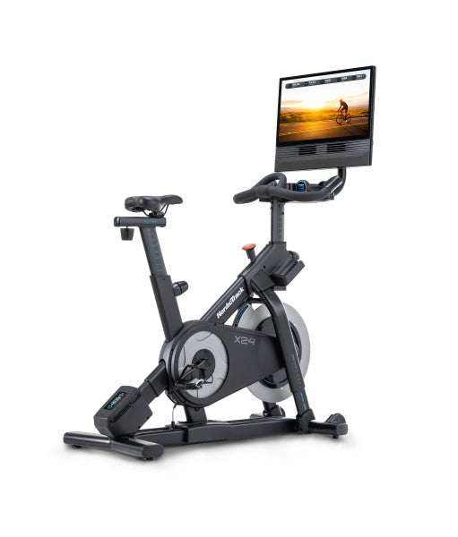 NordicTrack X24 Bike in black, with a large touchscreen, adjustable handlebars, and sturdy frame with flywheel cover
